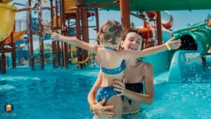 Família aproveitando resort no Nordeste com crianças brincando na piscina